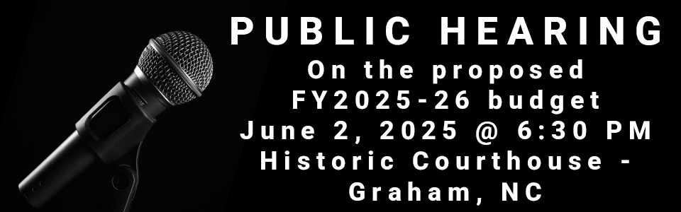 Image of microphone, announcing a public hearing on the FY2025-26 budget on June 2 2025, 6:30PM, at the Historic Courthouse in Graham, NC